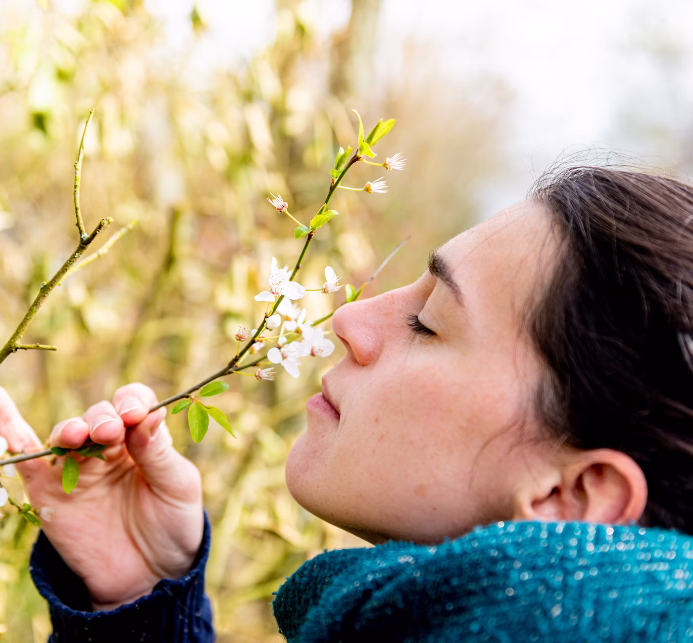 Femme sentant une fleur jaune au printemps